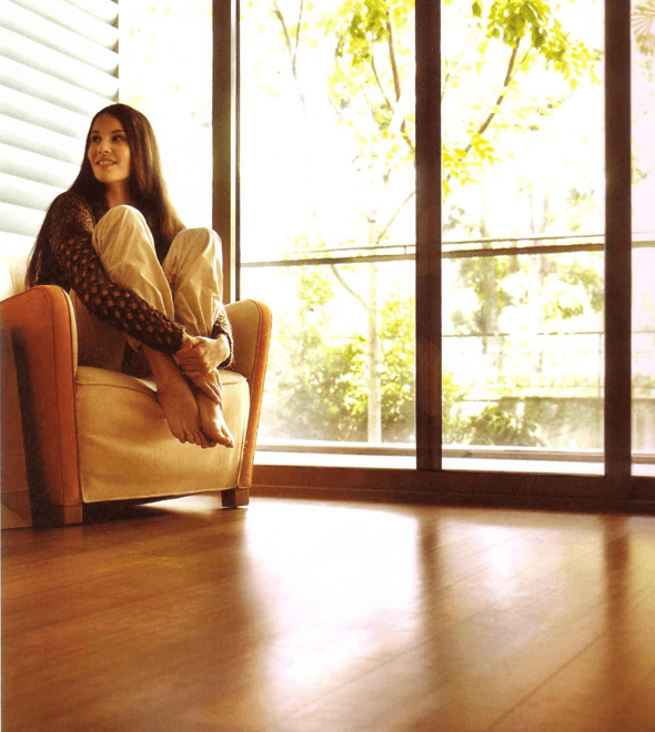 A homeowner relaxing in a clean, sunlit room